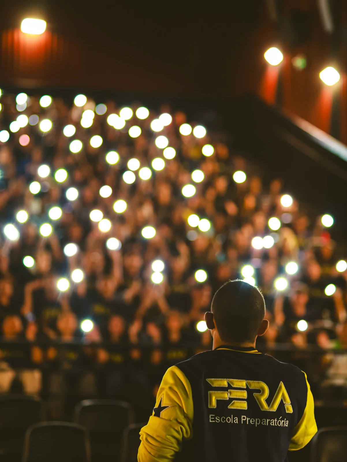 Encontro FERA em uma sala de cinema iluminada pelos celulares dos alunos