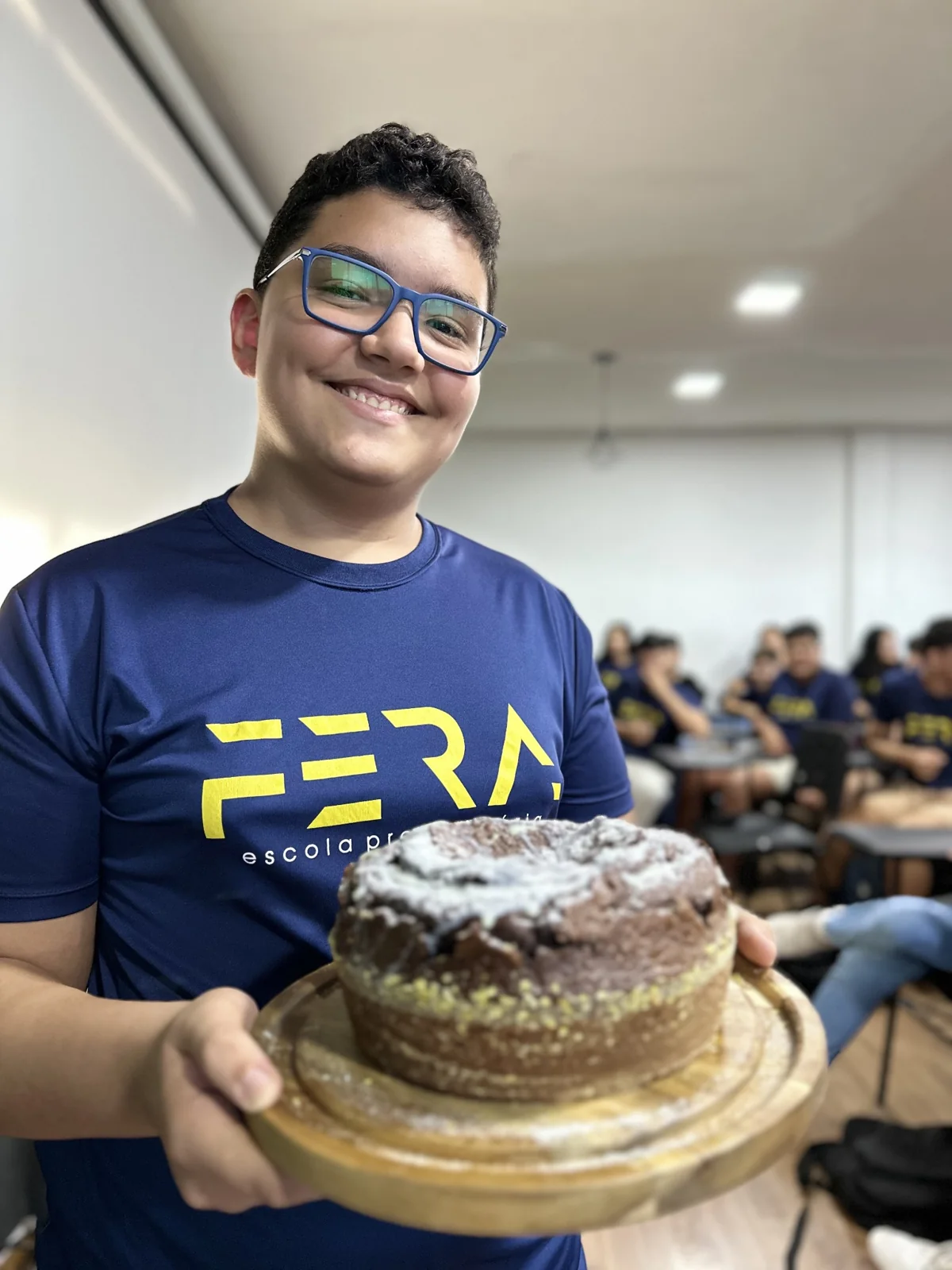 Aluno segurando o bolo de uma aula prática de Matemática